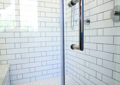 A walk in shower with tiled walls and floor.