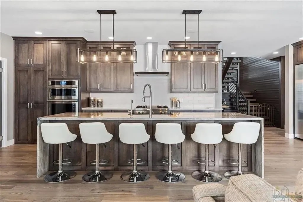 A kitchen with lots of counter and bar stools.