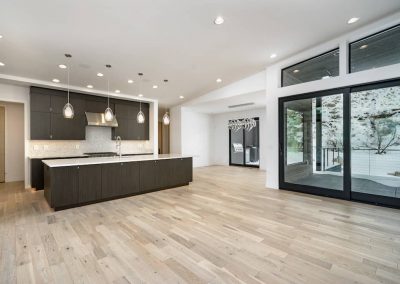 A large open kitchen with wood flooring and white walls.