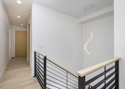 A staircase with a metal railing and white walls.