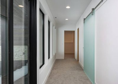 A hallway with two doors and a window.
