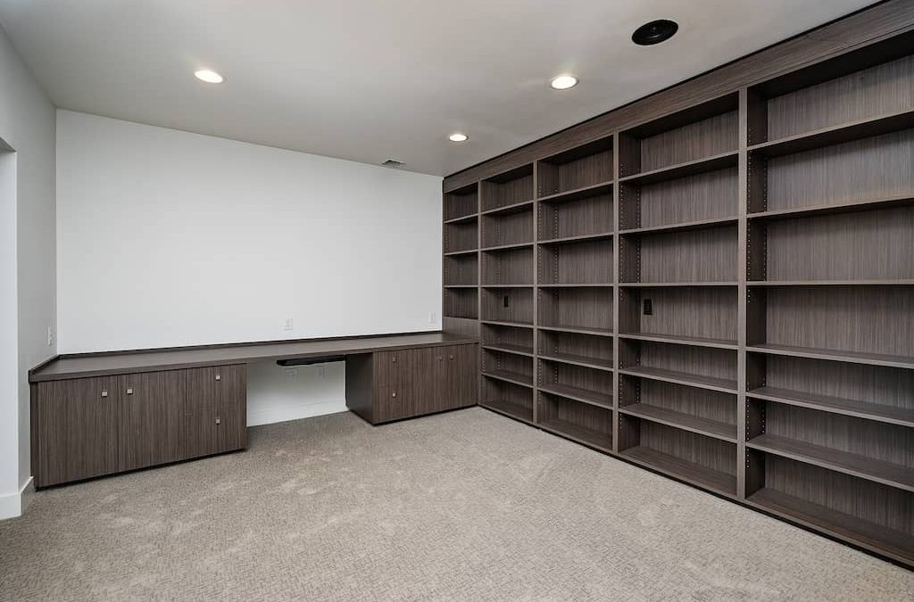 A room with many shelves and a desk