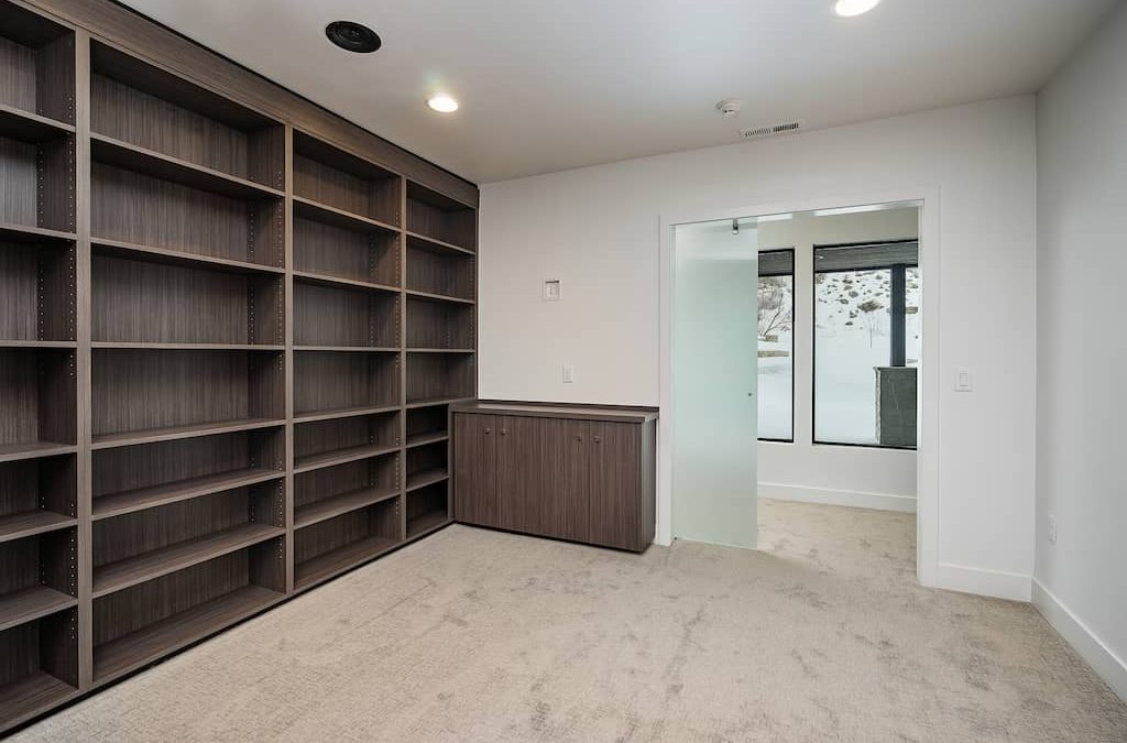 A room with many shelves and a desk
