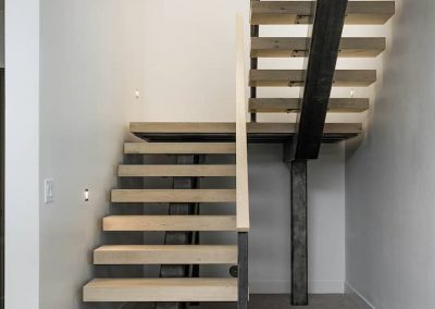 A wooden staircase with metal railing and wood steps.