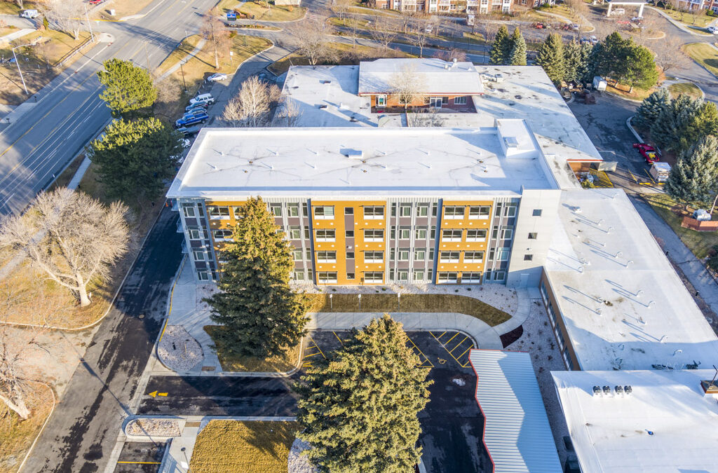 An aerial view of a building with snow on the roof.