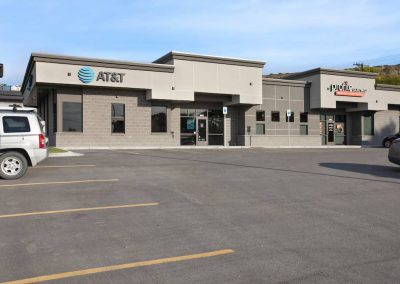 A large empty parking lot with an at & t store.