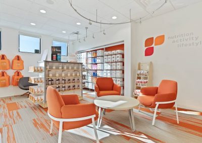 A room with orange chairs and tables in it