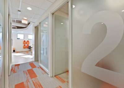 A hallway with orange and white carpet in it.