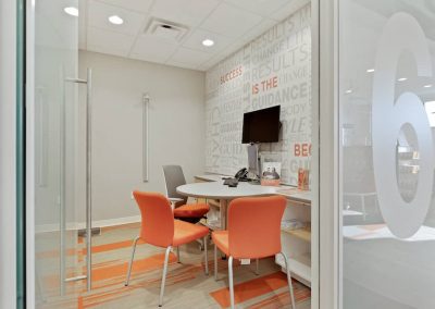 A room with orange chairs and a table
