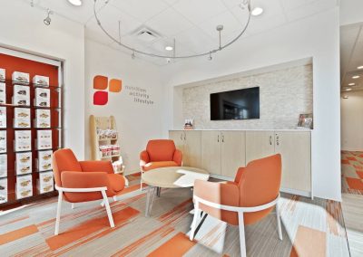 A room with orange chairs and a television.
