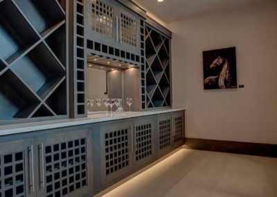 A room with a wine cellar and a bar.