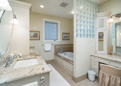 A bathroom with two sinks and a tub
