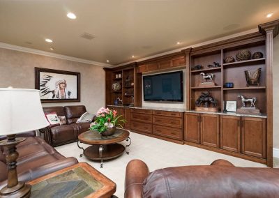 A living room with brown leather furniture and a large tv.